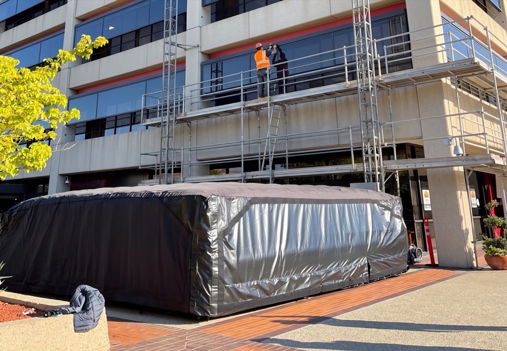 BAGJUMP soft-landing airbag deployed at the base of a high-rise building during active facade and scaffolding work